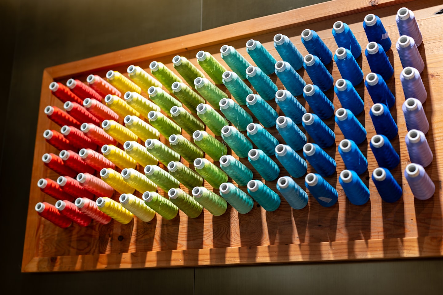 A rack of threads in the colours of the rainbow.
