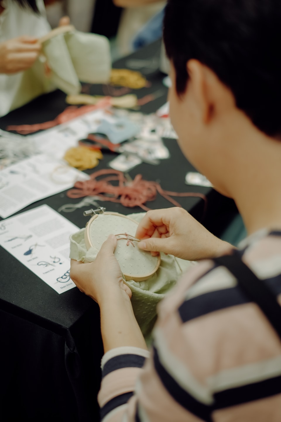 A woman embroidering a floral pattern