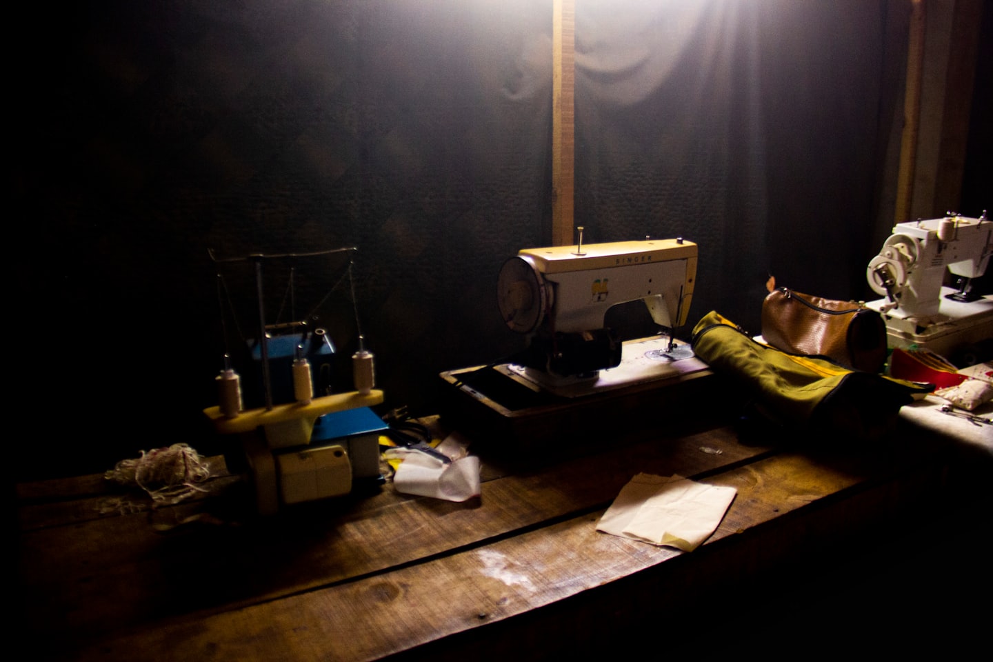 Sewing machine next to a serger on a wooden table.